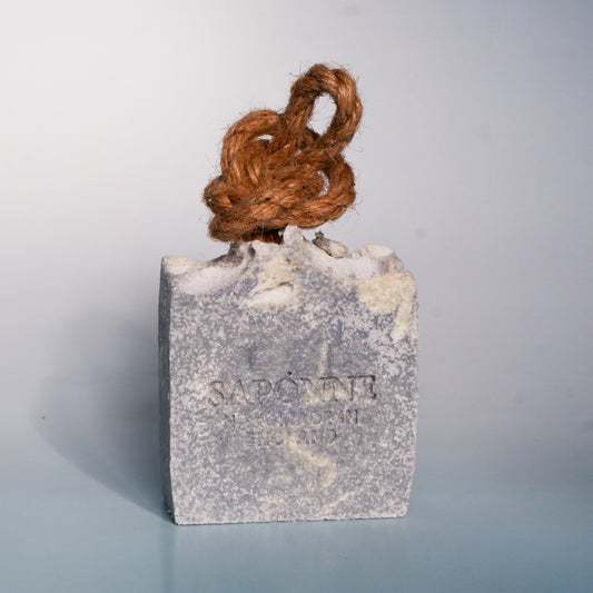 Bar of soap with a rope on top against a light gray background