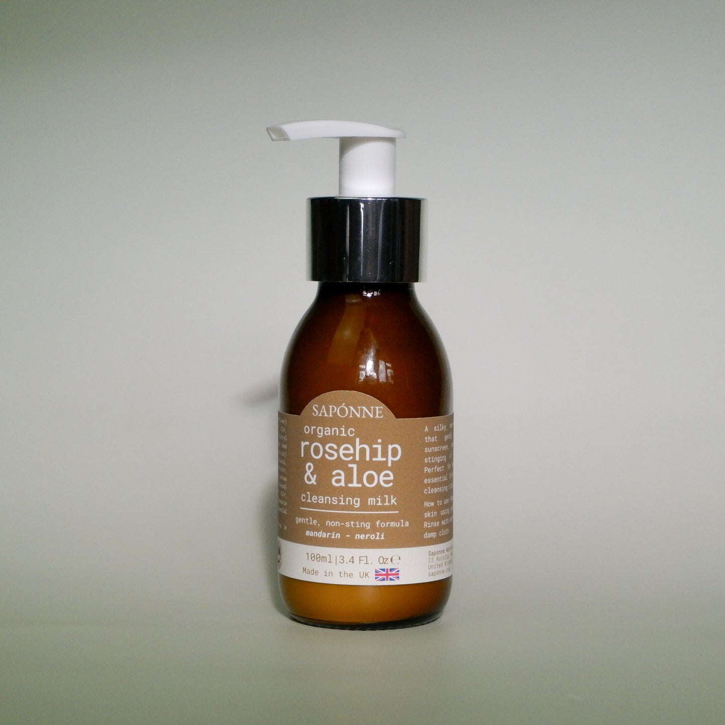 Brown bottle with a white pump labeled 'Saponne organic rosehip & aloe cleansing milk' on a light gray background