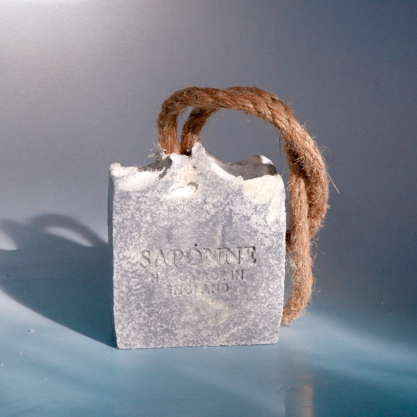 Bar of soap with 'Saponne' branding on a gray background