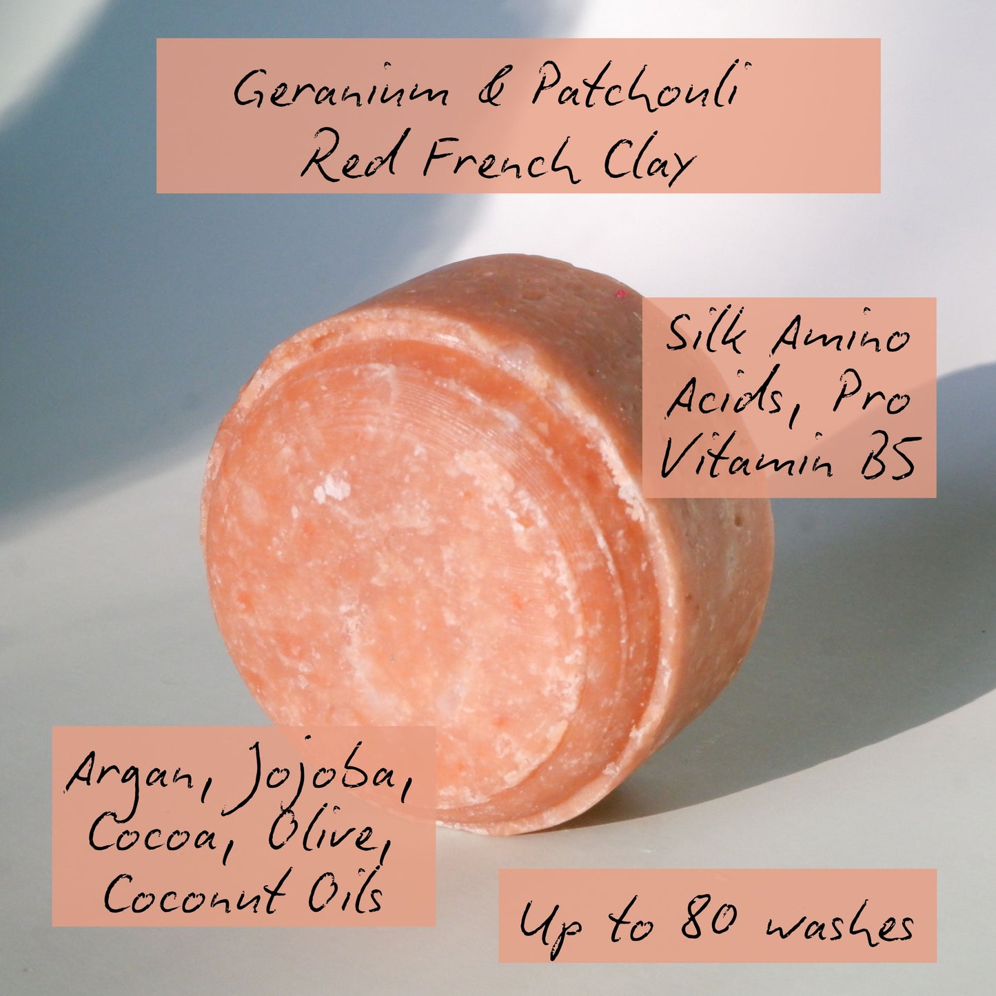 Pink bar of soap with text detailing ingredients and benefits on a light background