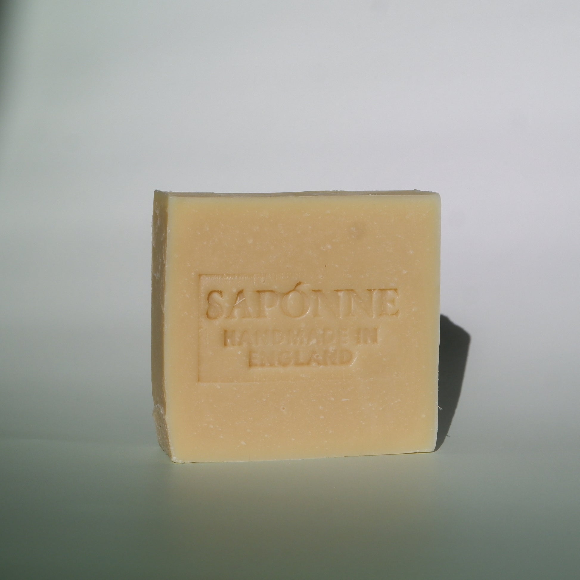 Bar of soap with 'Sapone' branding on a light gray background