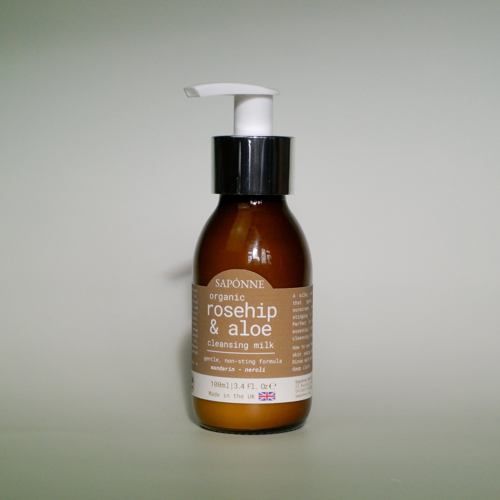 Brown bottle with a white pump labeled 'Saponne organic rosehip & aloe cleansing milk' on a light gray background