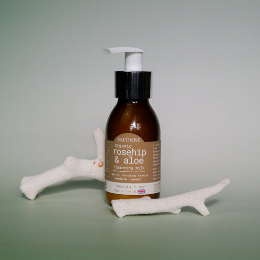 Brown bottle with pump and label on a light gray background
