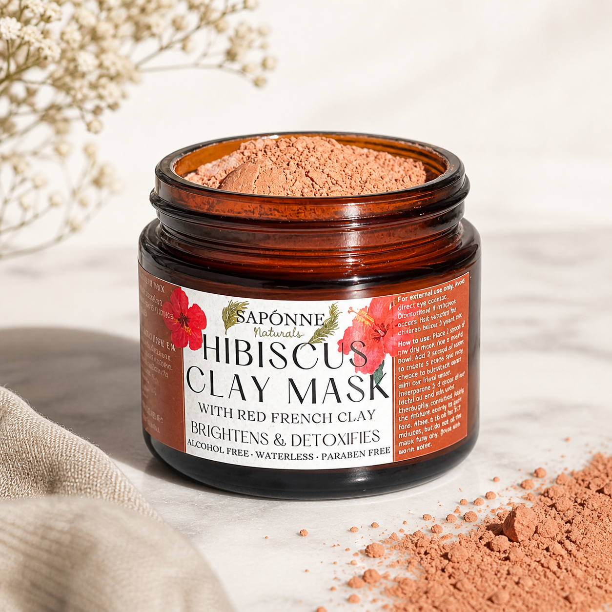Jar of Saponne Naturals Hibiscus Clay Mask with floral design on label